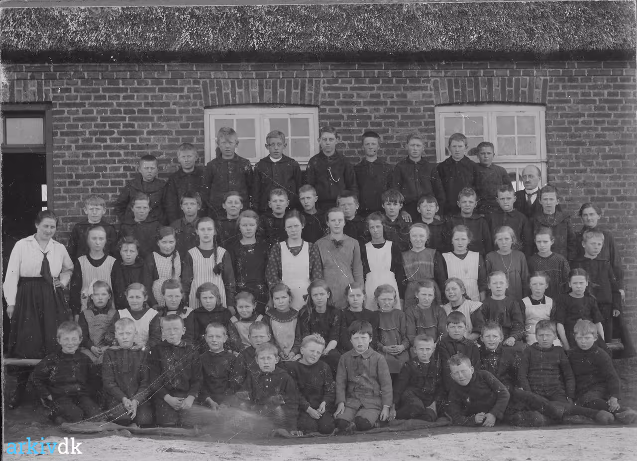 Elever og lærere foran Husby Skole i 1919, opstillet i fem rækker foran den stråtækte skolebygning