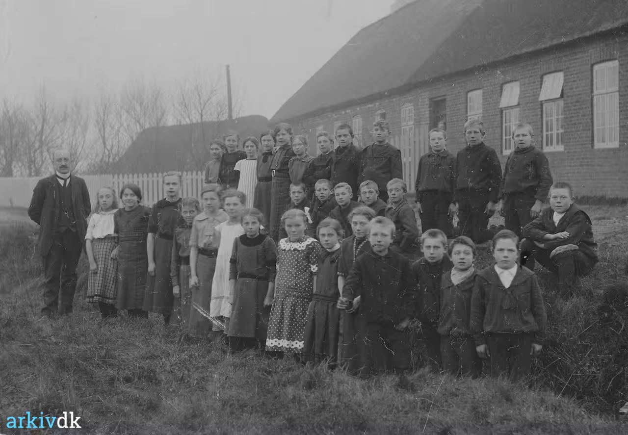 Elever og lærer foran Husby Skole i 1915; forrest i rækken står Ellen Silkjær som nummer tre fra venstre