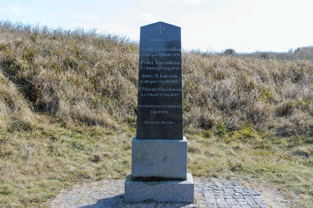 Sort mindesten med kors på granitsokkel i klitlandskab ved Renderne, med fire navne og teksten Forulykket paa Vesterhavet 1 April 1896